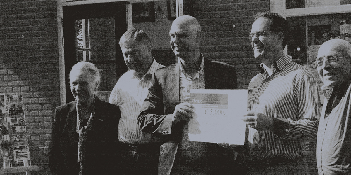 Zwart wit foto van de leden van het bestuur en Raad van Toezicht van het Historisch Museum Elspeet en een vertegenwoordiger van de Rabobank